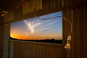 Lightbulb in Galvanised Iron Shed with Last Rays of Sun Shining